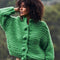 model wearing green chunky knit cardigan with large buttons and brown corduroy pants