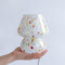 model holding white mini mushroom lamp with multicolor streaks