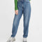 model wearing tapered high waist denim, green shirt and sneakers