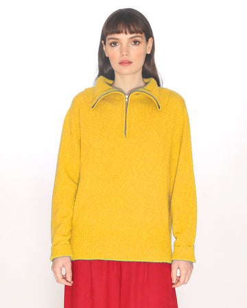 model wearing yellow quarter zip neck sweater with red skirt