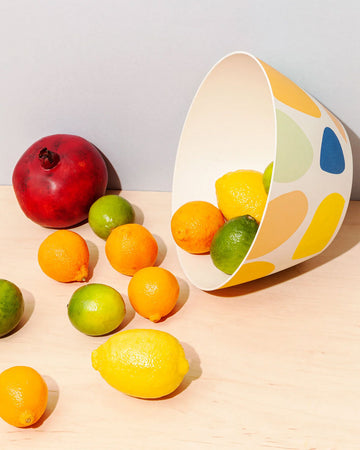 cream bowl with colorful pebble design with fruit spilling out