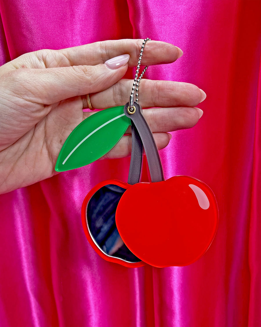 model holding cherry compact mirror to show size