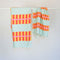 light blue turkish towel with yellow and orange lattice print and matching hand towel