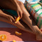 model eating a snack on beach blanket and pastel vertical stripe cooler bag next to her