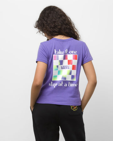 back-view of model wearing purple tee with 'take it one step at a time' vans graphic on back and black sweatpants