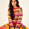 model wearing yellow, orange, green, pink and red crochet stripe sweater and print skirt