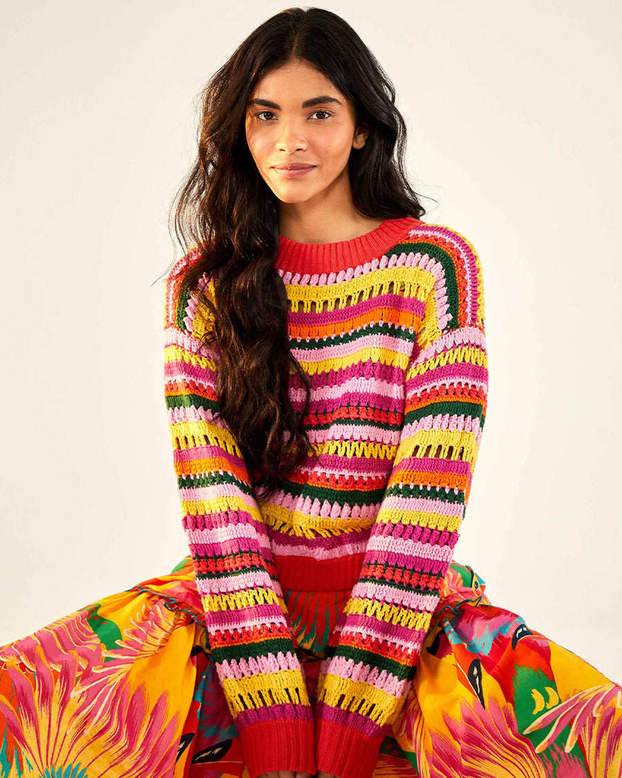 model wearing yellow, orange, green, pink and red crochet stripe sweater and print skirt