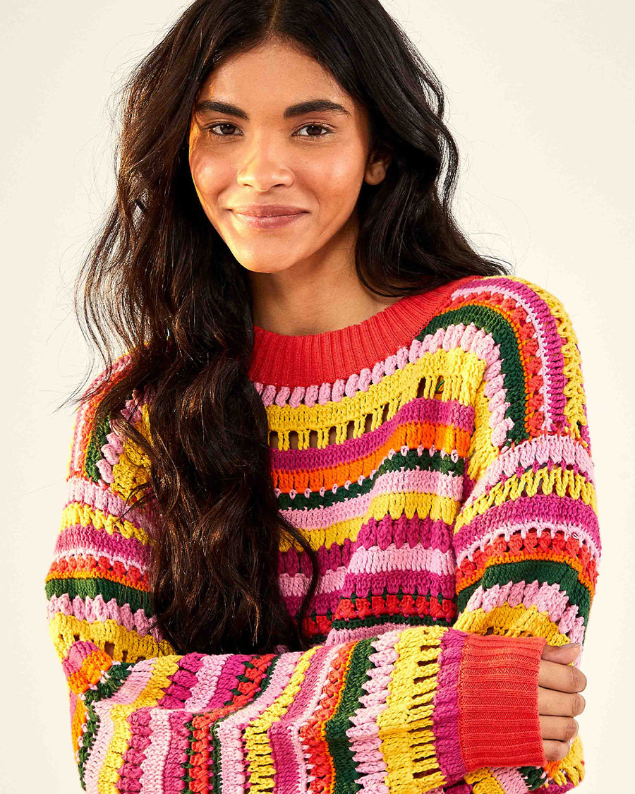 model wearing model wearing yellow, orange, green, pink and red crochet stripe sweater