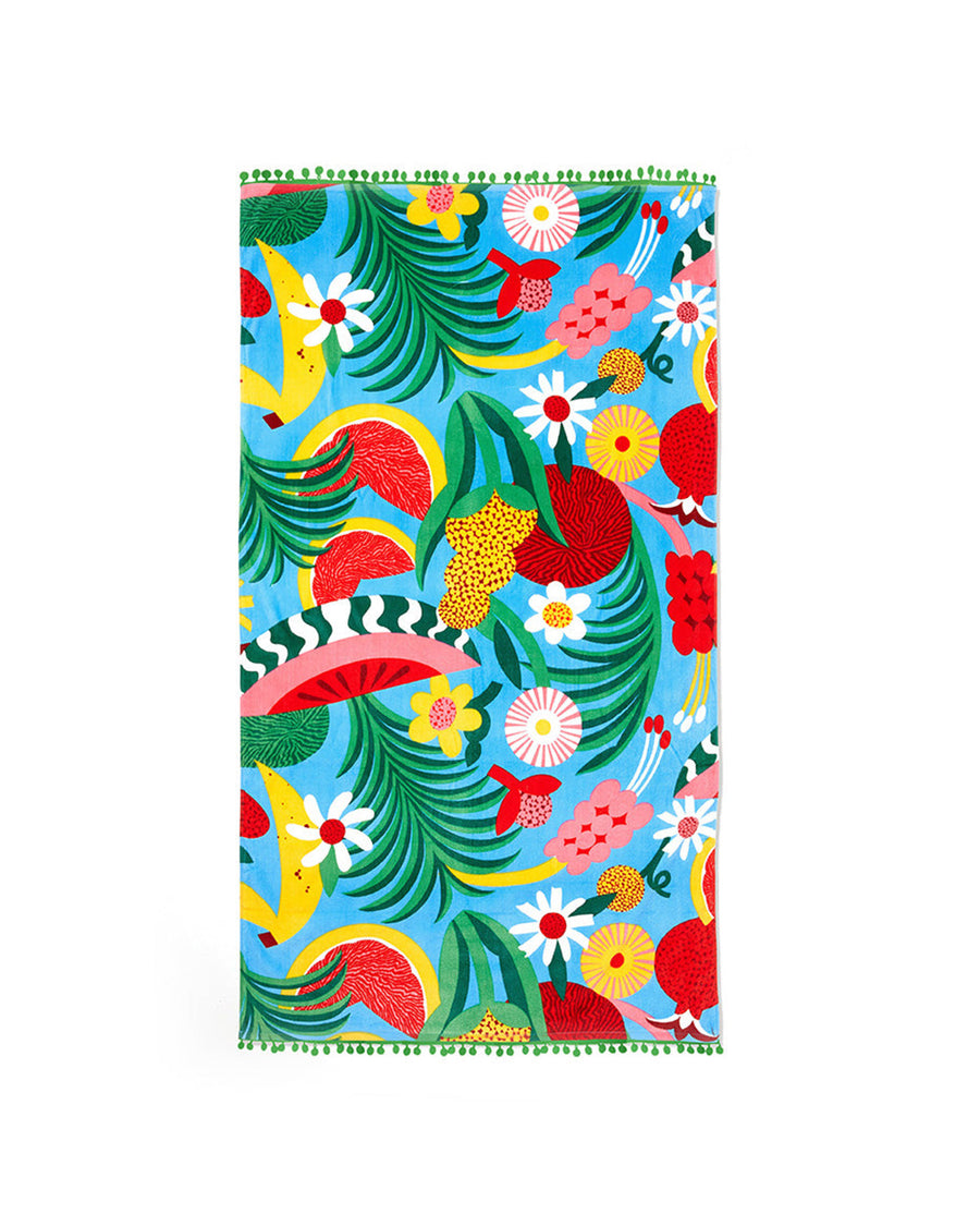 large beach towel with blue ground, abstract fruit print and green pom poms on each end