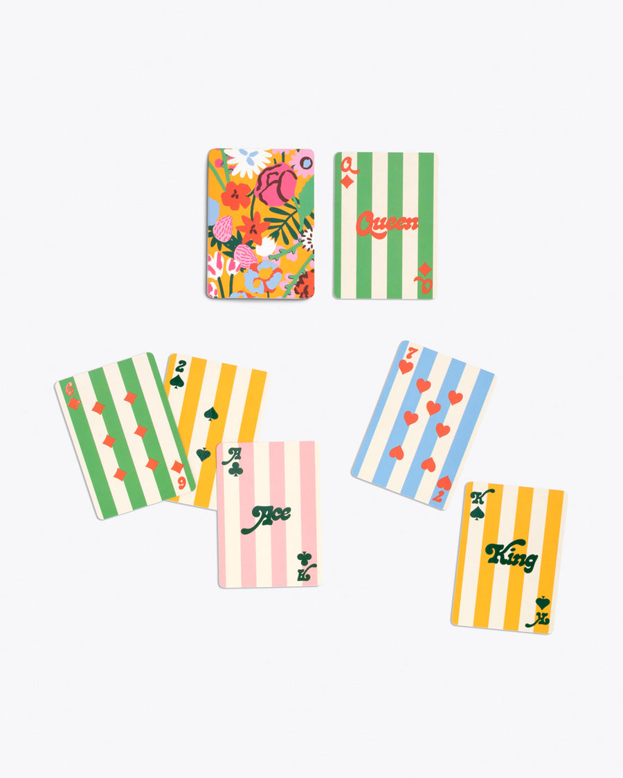 colorful playing card deck with multicolor floral design on back and assorted stripe pattern on front