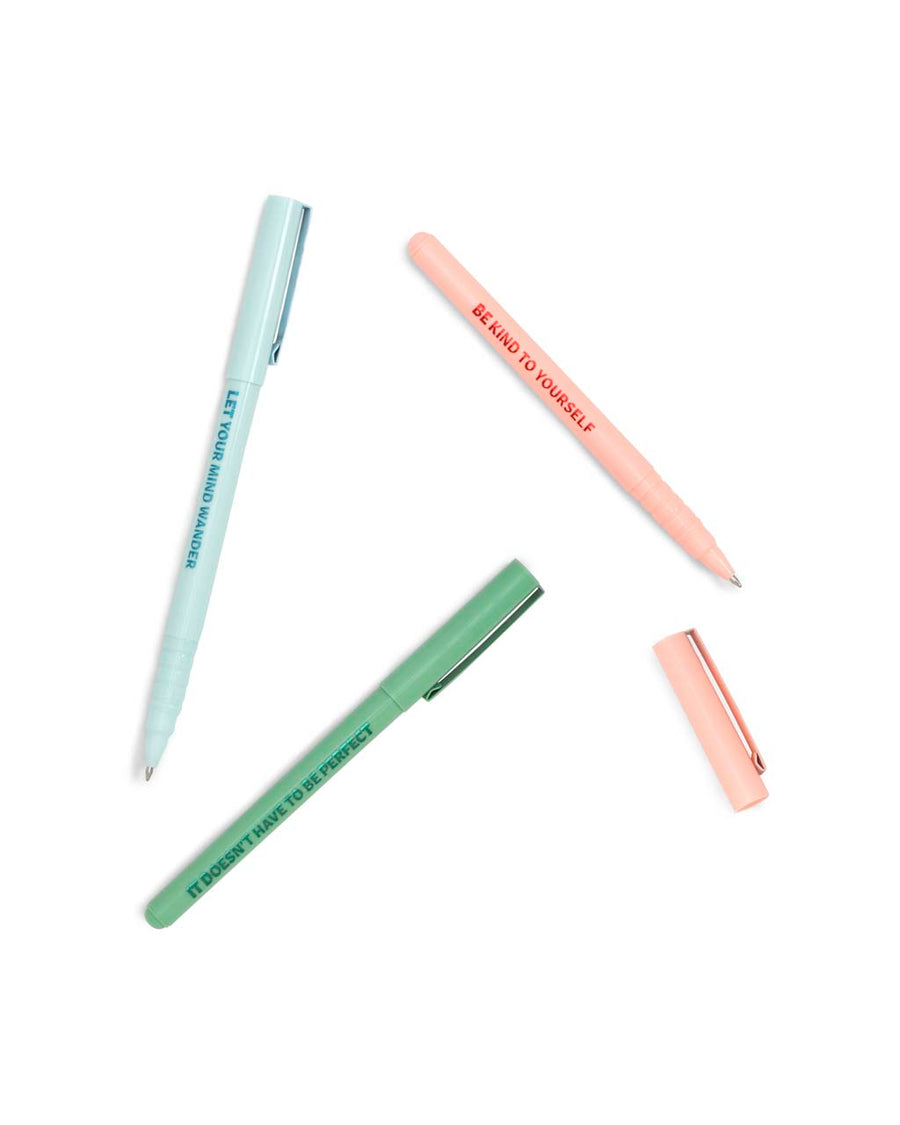 Set of three pens scattered on surface: One blue, one pink, one green